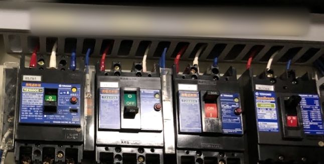 盤に並んだ遮断器と、色分けして結線した電線