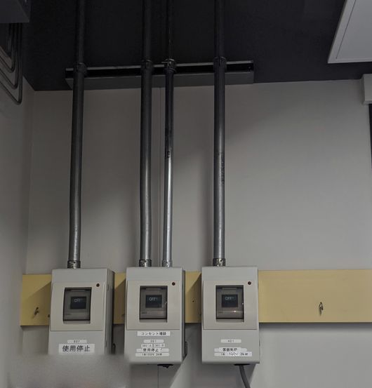 壁に並べて取り付けたブレーカーボックスと電線管